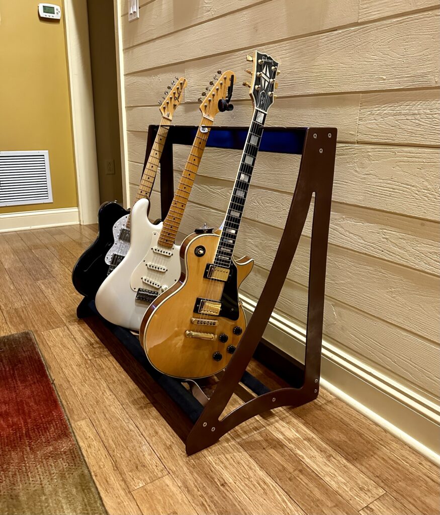 metal guitar rack holding 3 electric guitars